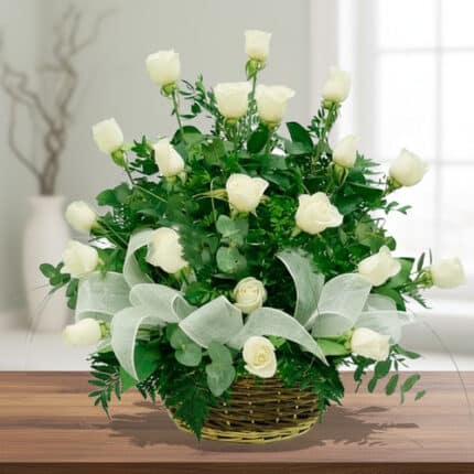 Arreglo floral de rosas blancas en canasta de mimbre sobre mesa de madera