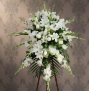 Arreglo floral grande de flores blancas con lirios y rosas sobre caballete de madera