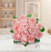 Ramo de rosas rosadas con hojas verdes sobre mesa de mármol blanco en sala moderna desenfocada