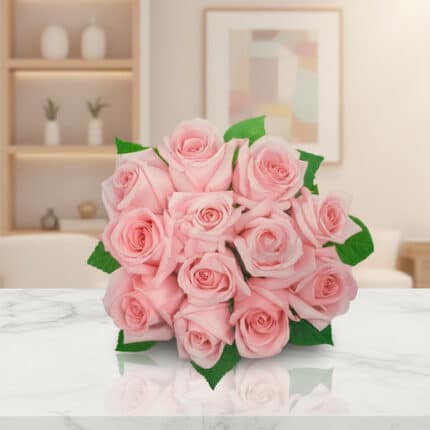 Ramo de rosas rosadas con hojas verdes sobre mesa de mármol blanco en sala moderna desenfocada