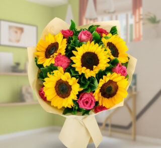 Ramo de flores con girasoles amarillos y rosas rosas envuelto en papel beige sobre fondo de salón desenfocado