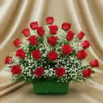 Arreglo de rosas rojas con gypsophila blanca en canasta verde sobre fondo dorado