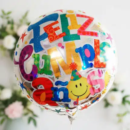 Globo redondo metálico con texto feliz cumpleaños en español y diseño multicolor con carita sonriente y estrellas