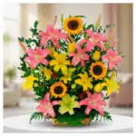 Arreglo de flores con lirios rosas y amarillos y girasoles en canasta de mimbre sobre mesa blanca en interior