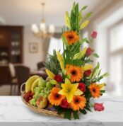 canasta de mimbre con frutas variadas y flores de colores sobre encimera de mármol en interior de casa