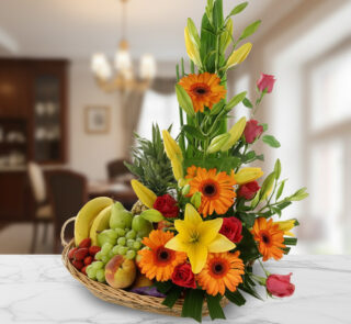 canasta de mimbre con frutas variadas y flores de colores sobre encimera de mármol en interior de casa