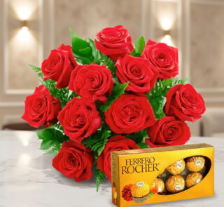 Ramo de rosas rojas sobre mesa de mármol junto a una caja de bombones Ferrero Rocher