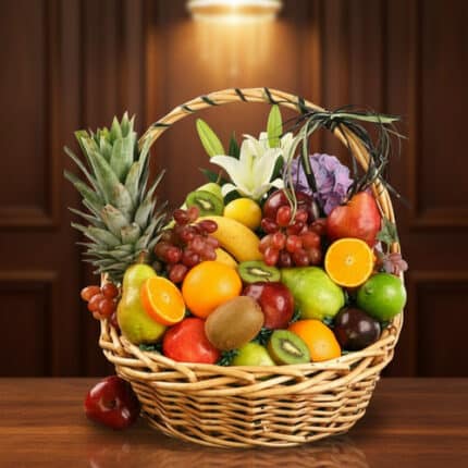 Cesta de mimbre llena de frutas frescas como piñas, naranjas, manzanas, uvas, kiwis y peras sobre una mesa de madera con fondo marrón