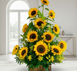 Arreglo de girasoles amarillos frescos en base rectangular de madera sobre mesa blanca en una sala luminosa