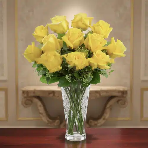 Ramo de rosas amarillas frescas en un jarrón de cristal tallado sobre una mesa de madera, con fondo interior elegante desenfocado