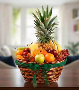 Canasta de mimbre con piña, uvas, manzanas, naranjas, plátanos y otras frutas variadas sobre una mesa de madera en sala desenfocada