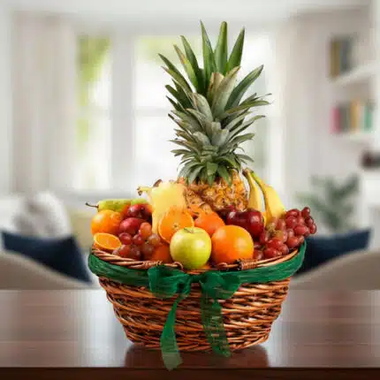 Canasta de mimbre con piña, uvas, manzanas, naranjas, plátanos y otras frutas variadas sobre una mesa de madera en sala desenfocada