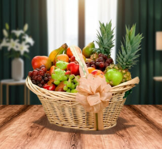 canasta de mimbre con lazo decorativo llena de frutas variadas como piñas, uvas, manzanas, peras y plátanos sobre mesa de madera con fondo de sala desenfocado