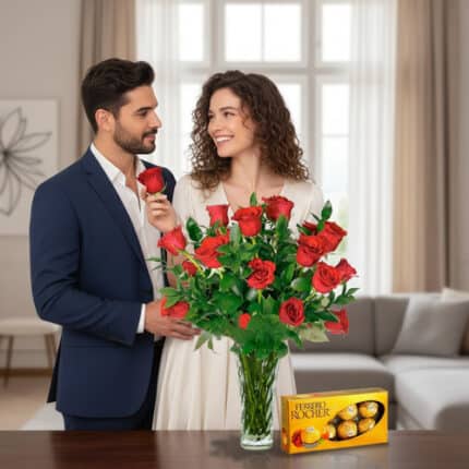Pareja elegante en sala luminosa, ella sostiene una rosa roja frente a un gran ramo de rosas en jarrón de cristal junto a una caja de bombones Ferrero Rocher sobre la mesa