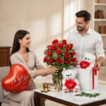 Hombre entrega a una mujer un ramo de rosas rojas junto a caja de regalo con osos de peluche blancos, globo rojo en forma de corazón y chocolates sobre una mesa