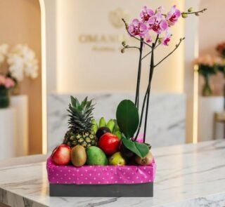 Arreglo ANTONELLO con orquídea Phalaenopsis rosa y frutas selectas como piña, manzanas, kiwis, mangos y aguacates, presentado