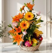 Arreglo Basilio, cesta frutal con rosas, lirios naranjas, gerberas amarillas, uvas, plátanos, manzanas, kiwi y pitahaya sobre