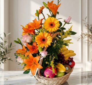 Arreglo Basilio, cesta frutal con rosas, lirios naranjas, gerberas amarillas, uvas, plátanos, manzanas, kiwi y pitahaya sobre