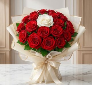 Arreglo floral ALESSIA con 23 rosas rojas vibrantes y una rosa blanca central, envuelto en papel coreano color crema con lazo