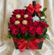 Arreglo floral ENRICO con rosas rojas frescas, botella de vino tinto y chocolates Ferrero Rocher, presentado en una caja negr