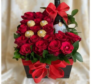 Arreglo floral ENRICO con rosas rojas frescas, botella de vino tinto y chocolates Ferrero Rocher, presentado en una caja negr