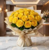 Arreglo floral Evelina con 24 rosas amarillas vibrantes, empaque coreano dorado y lazo, sobre mesa de mármol en un lobby de h