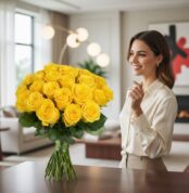 Mujer elegante admirando el Arreglo Floral Evelina, un ramo de 24 rosas amarillas vibrantes en un entorno de hogar lujoso y d