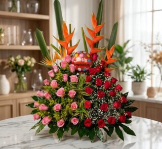 Impresionante arreglo floral exótico con rosas rojas y rosadas vibrantes, aves del paraíso y follaje exuberante, sobre una su