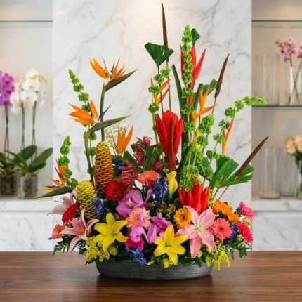 Arreglo floral exótico Fusión con aves del paraíso, lirios, orquídeas y flores tropicales vibrantes sobre mármol pulido, esti