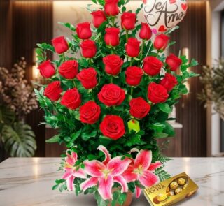 Arreglo Floral Exótico Gamma con rosas rojas abiertas, lirios rosados, follaje verde y chocolates Ferrero Rocher sobre mármol
