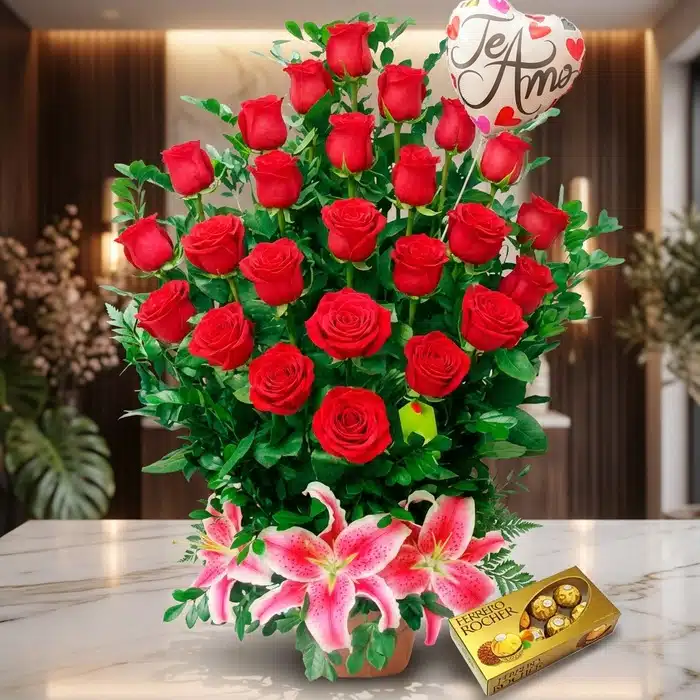 Arreglo Floral Exótico Gamma: Rosas Rojas y Lirios Vibrantes Arreglo Floral Exótico Gamma con rosas rojas abiertas, lirios rosados, follaje verde y chocolates Ferrero Rocher sobre mármol