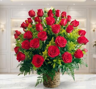 Arreglo floral exótico Secreto con rosas rojas grandes y abiertas, follaje verde exuberante en cesta de mimbre sobre mármol.