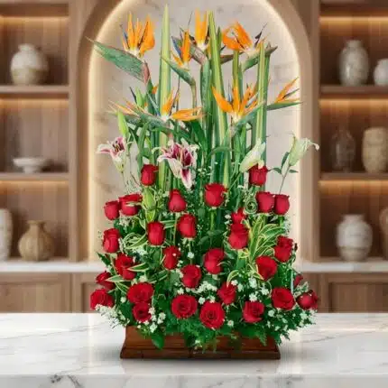 Impresionante arreglo floral exótico Tucana con rosas rojas vibrantes, lirios blancos y rosados, y aves del paraíso, sobre un