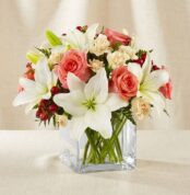 Arreglo floral Fabrizia con rosas rosadas, lirios blancos, claveles crema y bayas rojas en un jarrón de cristal cuadrado, ide