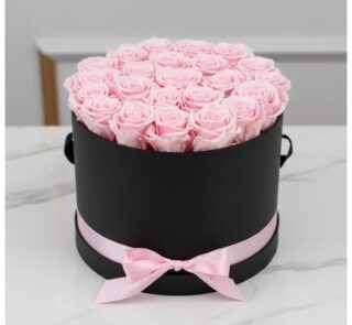Arreglo floral Francesca con 21 rosas rosadas preservadas en una caja cilíndrica negra con lazo rosa, ideal para regalo.