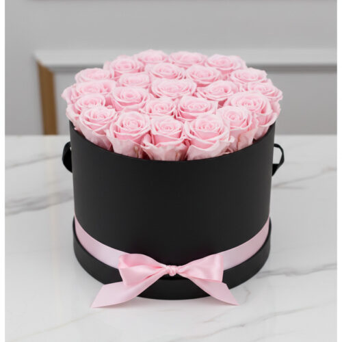 Arreglo floral Francesca con 21 rosas rosadas preservadas en una caja cilíndrica negra con lazo rosa, ideal para regalo.