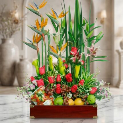 Arreglo floral Akebia con aves del paraíso, rosas rojas, lirios, orquídeas y frutas frescas sobre mármol, fondo de floristerí
