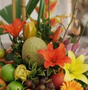 Primer plano extremo de Arreglo Floral con Frutas Alfa, mostrando texturas hiperrealistas, gotas de rocío y colores vibrantes