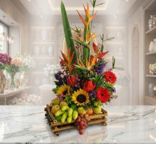 Arreglo floral exótico 'Bahamas' con aves del paraíso, girasoles, gerberas rojas y una base de frutas frescas como manzanas,