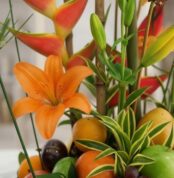 Primer plano extremo de un lirio naranja vibrante con gotas de rocío, parte del Arreglo Floral con Frutas Eclipse, mostrando