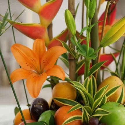 Primer plano extremo de un lirio naranja vibrante con gotas de rocío, parte del Arreglo Floral con Frutas Eclipse, mostrando