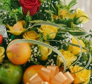 Primer plano extremo de un arreglo floral con rosas amarillas y rojas, manzanas verdes y naranjas, con sutiles gotas de rocío
