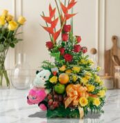 Arreglo Floral con Frutas Encanto, con rosas rojas y amarillas, aves del paraíso, uvas, manzanas, naranjas y un peluche, sobr