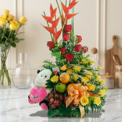 Arreglo Floral con Frutas Encanto, con rosas rojas y amarillas, aves del paraíso, uvas, manzanas, naranjas y un peluche, sobr