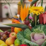 Primer plano extremo de un arreglo floral con frutas Hawai, mostrando texturas hiperrealistas, gotas de rocío y colores vibra