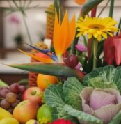 Primer plano extremo de un arreglo floral con frutas Hawai, mostrando texturas hiperrealistas, gotas de rocío y colores vibra