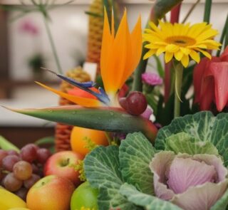 Primer plano extremo de un arreglo floral con frutas Hawai, mostrando texturas hiperrealistas, gotas de rocío y colores vibra