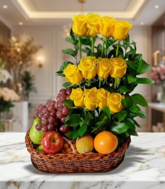 Arreglo floral con rosas amarillas vibrantes y frutas frescas como uvas, manzanas, peras y naranjas en una cesta de mimbre, s