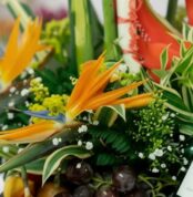 Primer plano extremo de un arreglo floral con frutas Platonia, destacando la textura hiperrealista de las flores, sutiles got