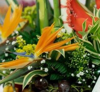 Primer plano extremo de un arreglo floral con frutas Platonia, destacando la textura hiperrealista de las flores, sutiles got